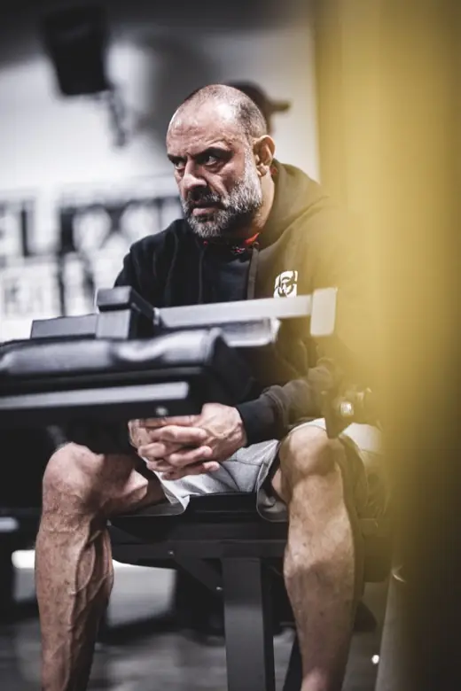 Ashkan Aghili sitter på en bänk mellan set med händerna knäppta