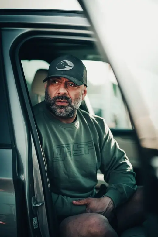 Ashkan Aghili sitter i dörröppningen till en skåpbil och tittar in i kameran